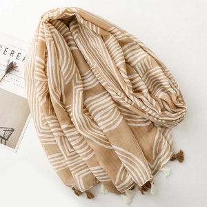 Close-up of linen-feel shawl with geometric patterns and soft fringed tassels