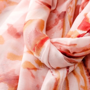 Macro detail of high-quality watercolor print fabric with soft pink and orange ink patterns