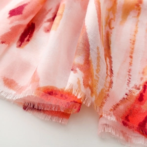 Detail of pink ink painting scarf showing soft fabric texture and fringe tassels