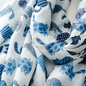 Detailed view of lightweight white scarf featuring blue and grey cartoon cat prints