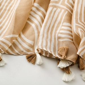 Macro shot of cotton linen scarf edge with geometric lines and bicolor tassels detail
