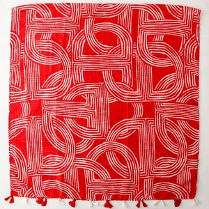 Macro shot of red cotton linen scarf featuring white geometric lines and fringe details