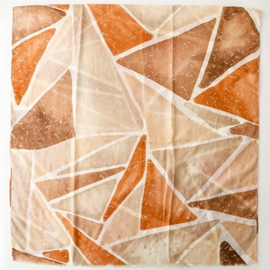 Dettaglio di sciarpa effetto cotone-lino con motivi geometrici a triangoli arancioni
