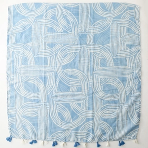 Detail of light blue linen-feel scarf featuring white arch patterns and tassel trim