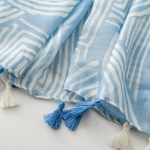 Close-up of light blue and white striped cotton-linen shawl with fringe tassels
