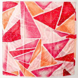Dettaglio di foulard in seta geometrico con texture dorata e bordi sfrangiati