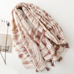 Elegant long scarf with soft wavy stripes and tassels, displayed with a lifestyle magazine