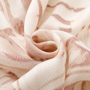 Close-up of soft cotton-linen fabric with brown wavy patterns and breathable texture