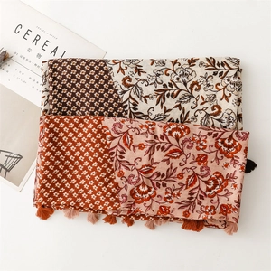 Close-up of floral print scarf showing delicate tassels and soft linen texture finish