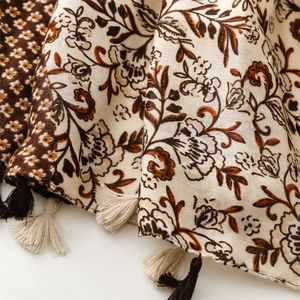 Detailed close-up of thick floral scarf featuring soft dual-color handmade tassels