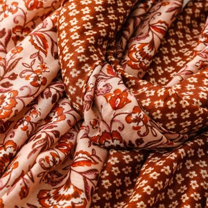 Macro texture of boho floral print scarf with warm earth tones and soft woven fabric