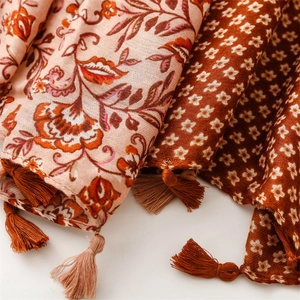 Close-up of bohemian floral scarf with soft cotton-linen texture and fringe tassels