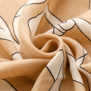 Macro shot of cotton-linen feel scarf showing textured weave and beige geometric patterns