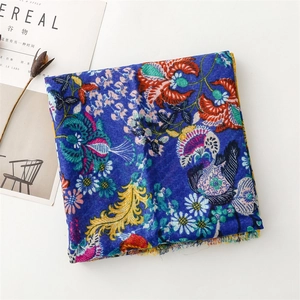 Detail of bohemian floral print scarf with tassels and colorful ethnic patterns