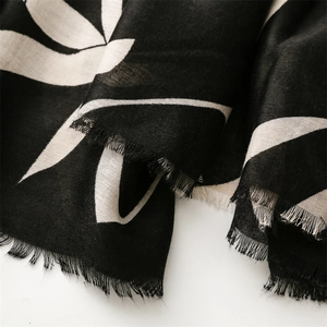 Detail of cotton linen scarf showing large leaf pattern and natural frayed edges