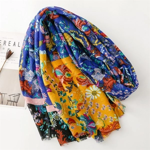 Detail of floral printed cotton linen scarf with blue and gold ethnic patterns and raw edges
