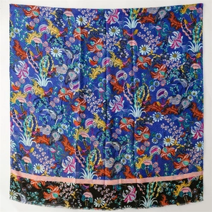 Close-up of vintage floral and bird patterns on thick blue cotton-linen scarf shawl