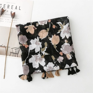 Detail of floral linen scarf featuring artistic rose prints and hand-tied fringe trim