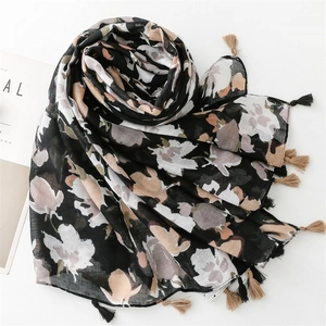 Detailed view of floral cotton scarf featuring pink roses and black fringe tassels