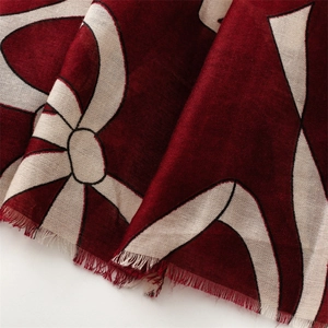 Detailed macro view of burgundy linen scarf showing soft fringe and abstract patterns