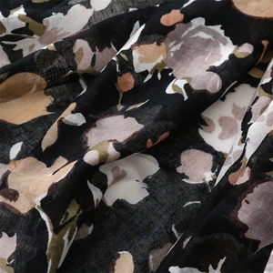 Detailed close-up of abstract floral print on dark cotton-linen feel scarf fabric