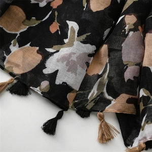 Detail of cotton linen scarf featuring vintage floral print and black tassel fringe