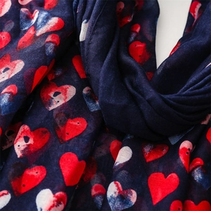 Detail of soft cotton-linen scarf with red and white hand-drawn heart patterns