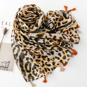 Detailed view of leopard print scarf with vibrant orange fringe and soft cotton-linen texture