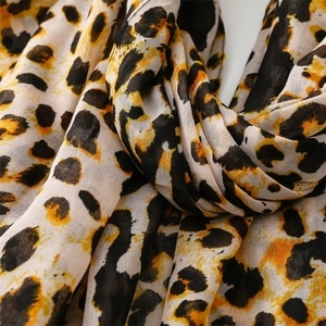 Macro shot of gold leopard print scarf showing soft texture and lightweight woven fabric