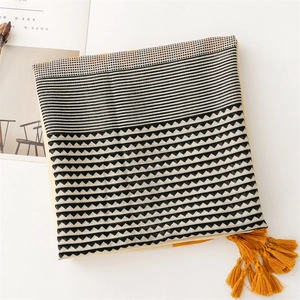 Detailed texture of cotton linen scarf with geometric patterns and yellow tassels