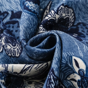 Detailed close-up of blue and white floral pattern on soft cotton linen scarf fabric