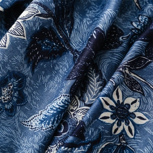 Macro shot of dark blue cotton scarf fabric with white floral peony patterns and texture