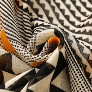 Detail of soft cotton-linen scarf with geometric patterns and fringe texture