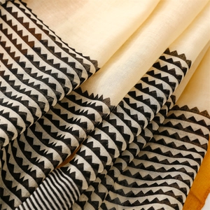 Detail shot of cotton linen scarf with geometric triangles and orange border accents