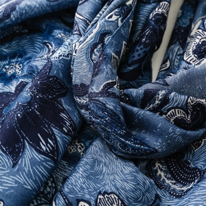 Detailed close-up showing soft cotton-linen texture and vintage floral print on blue scarf