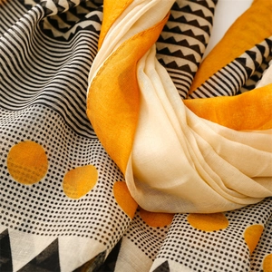 Macro shot of geometric print scarf showing linen texture with yellow and black patterns