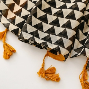 Detail of geometric triangle print cotton linen scarf with vibrant yellow tassels