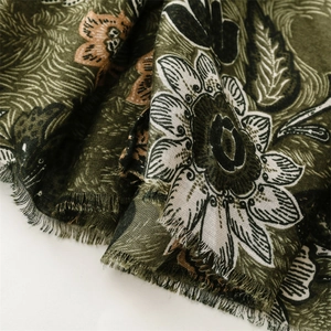 Detail of vintage floral pattern on olive green linen scarf with short fringe edges