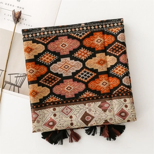 Detail of bohemian geometric print scarf with colorful patterns and tassel fringe edge