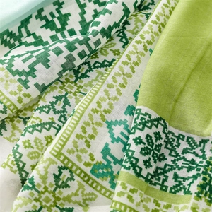 Detailed macro view of bohemian green geometric pattern on cotton-linen feel shawl fabric