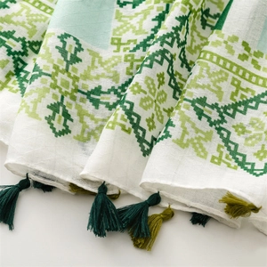 Detail of green geometric pattern fabric with soft tassels and cotton-linen texture