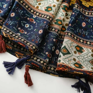 Macro detail of bohemian geometric scarf fabric with dark blue patterns and tassels