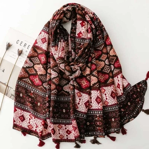 Detail of bohemian geometric shawl with cotton-linen feel and fringe tassels on white background