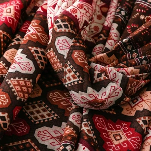 Detail of bohemian geometric print scarf fabric with deep red and brown tribal patterns