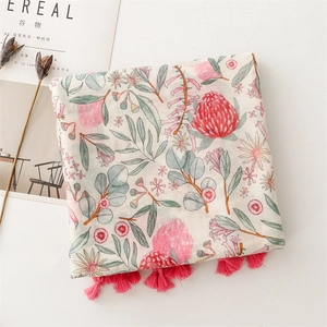 Detail of floral print scarf with pink tassels and elegant protea flower patterns