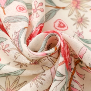 Detail of pink floral cotton linen scarf showing soft texture and fringe tassels