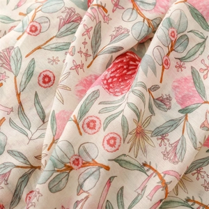 Macro detail of soft cotton-linen scarf fabric with pink floral patterns and fringes