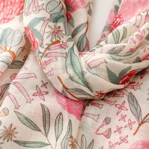 Close-up of soft linen-touch scarf featuring pink pomegranate floral prints and fringe