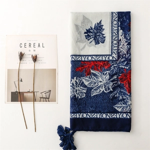 Detailed view of leaf print scarf with navy tassels and elegant border design