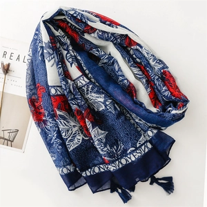 Detail of leaf pattern cotton-linen scarf with red and blue borders and tassels
